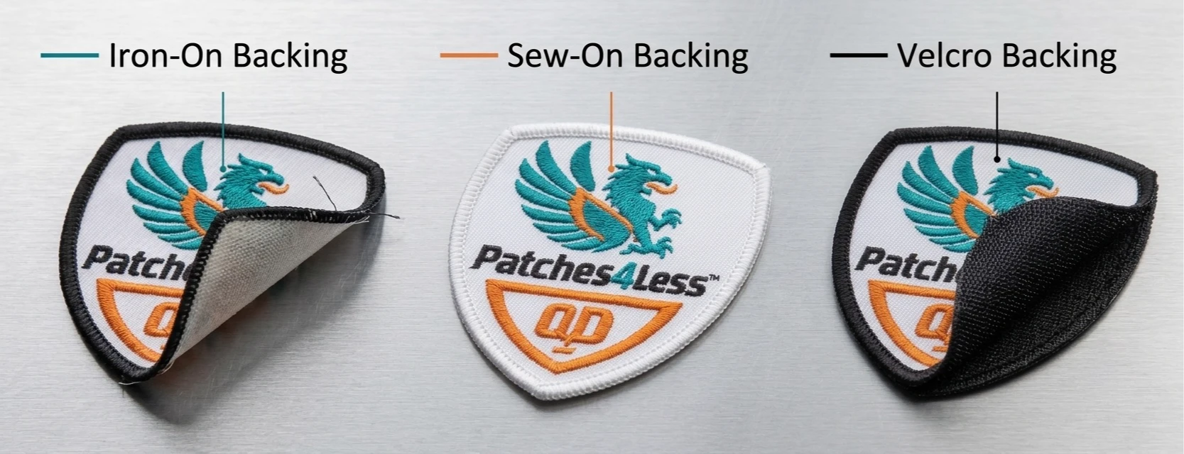 Three embroidered patches, each with the corner peeled up to reveal a different backing: iron-on heat-seal adhesive, plain sew-on twill, and black hook-and-loop Velcro