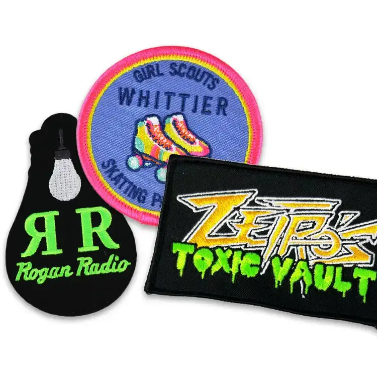 Three patches stitched in neon green, pink, and yellow thread
